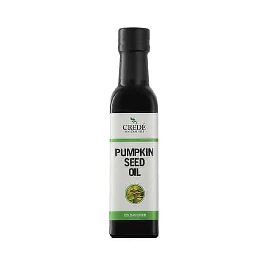 Crede Pumpkinseed Oil in a dark green bottle with a pour spout, showcasing the rich, dark green oil, perfect for salads and skin care.