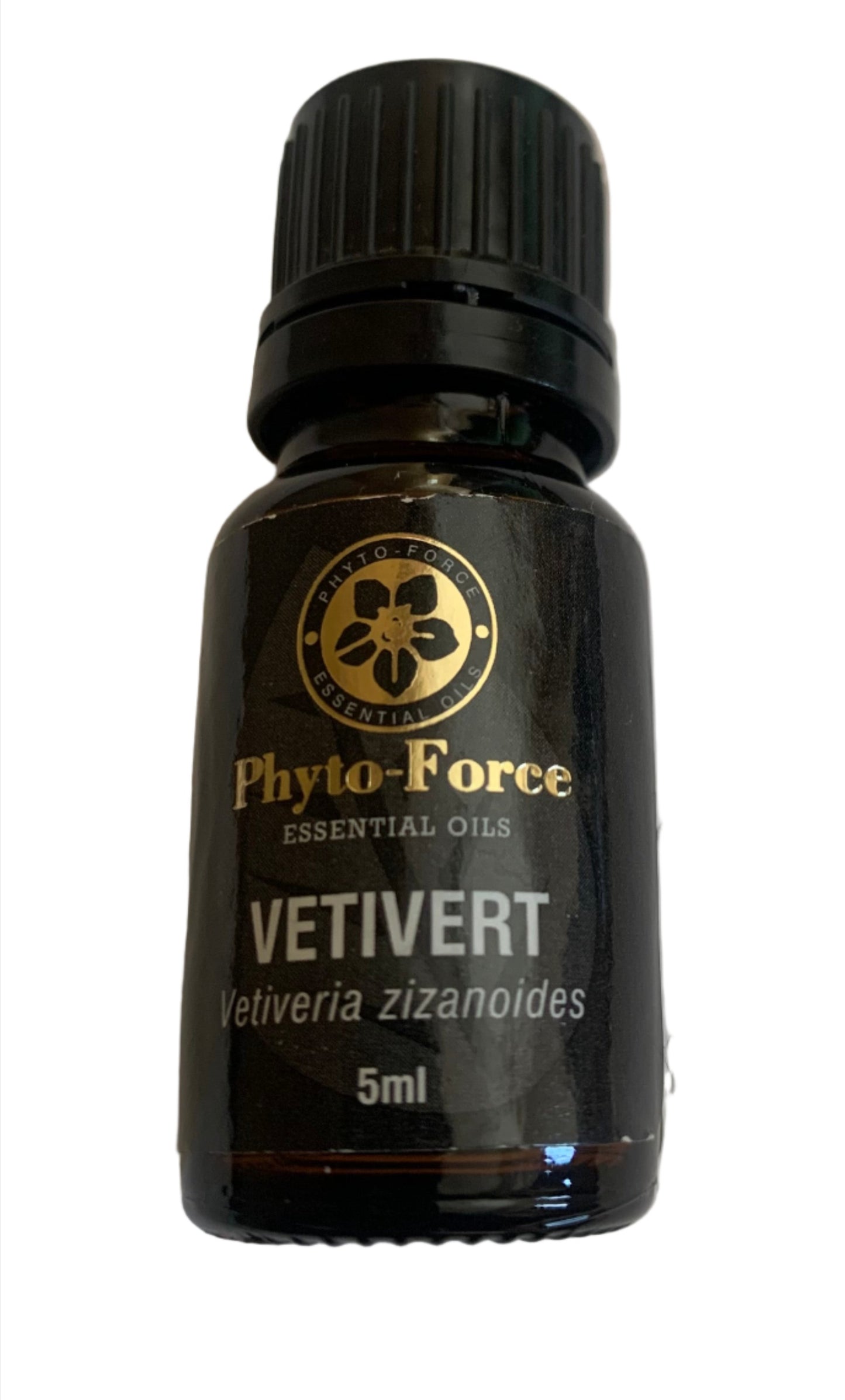 A bottle of Phyto-Force Organic Vetivert Essential Oil with its natural and organic label, placed next to vetiver roots.
